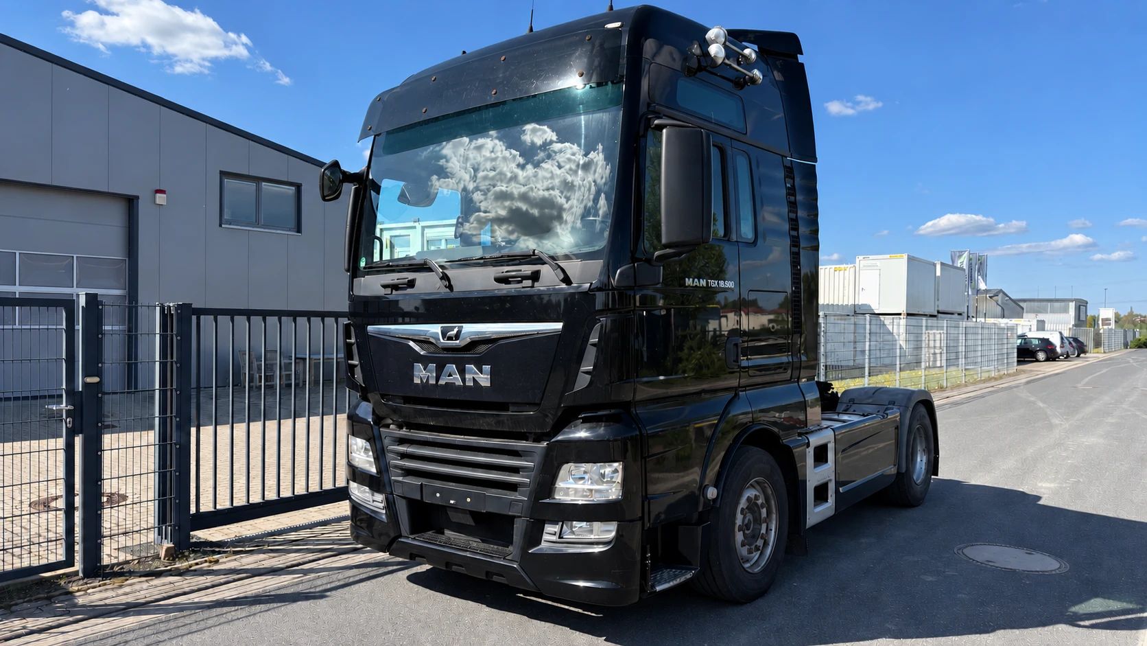 Gebrauchte Sattelzugmaschine MAN TGX 18.500 in Schwarz auf dem Hof